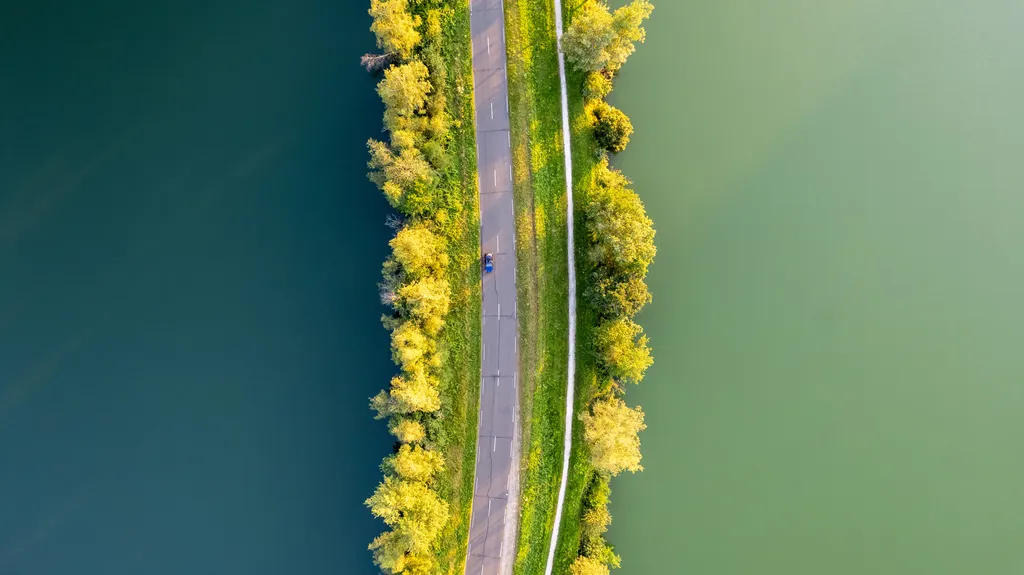 Route au milieu des étangs et des couleurs automnales